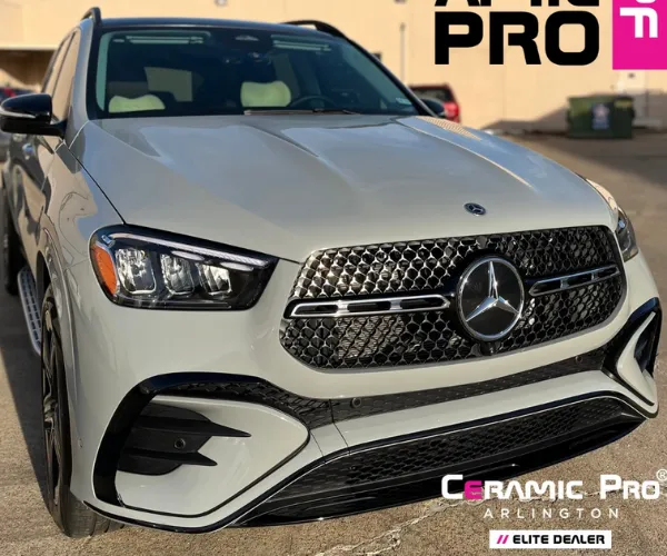 view of a clean luxury car parked inside a brightly lit professional detailing garage