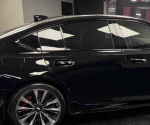 view of a glossy black sedan with dark tinted windows