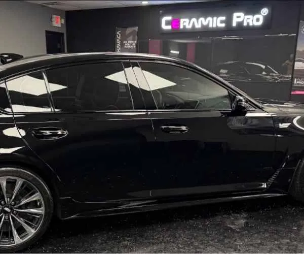 view of a glossy black sedan with dark tinted windows